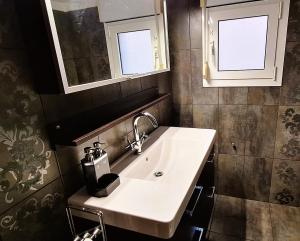 a bathroom with a sink and two windows at Zen Villa Porto Molo in Ávdhira +10 photos