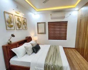 a bedroom with a large bed with pillows on it at Tranquil Home in Trivandrum