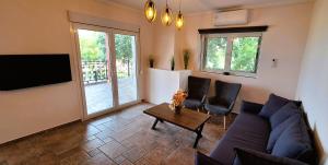 a living room with a couch and a table at Zen Villa Porto Molo in Ávdhira