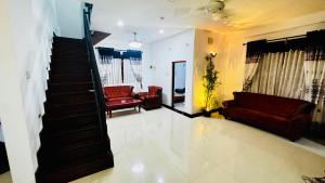 a living room with two couches and a staircase at Premier Villa Tangalle in Tangalle