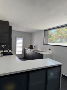 a kitchen with white counters and a large window at Villa Baena in Granada