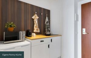 a kitchen with a microwave and a counter top at MONTAGO Monteur-Apartmenthaus Frankfurt Airport in Neu Isenburg +7 photos