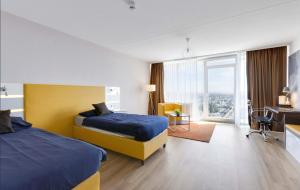a hotel room with two beds and a desk at MONTAGO Monteur-Apartmenthaus Frankfurt Airport in Neu Isenburg