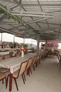 a group of tables and chairs under a roof at Guest House RosAmado in São Filipe
