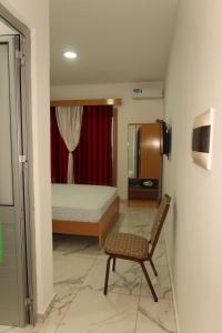 a bedroom with a bed and a chair in it at Guest House RosAmado in São Filipe