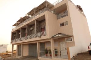 a building with balconies on the side of it at Guest House RosAmado in São Filipe