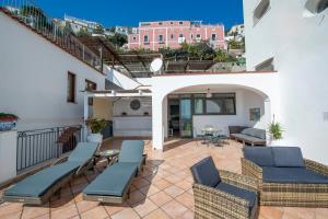 a patio with chairs and tables on a balcony at Casa Marina in Praiano