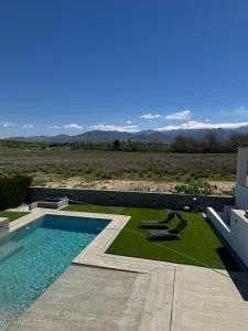 a swimming pool with two chairs and a view of the desert at Villa Baena in Granada