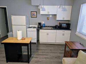 a kitchen with white appliances and a table in it at Spacious Studio near Brady St in Milwaukee