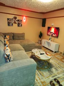 a living room with two couches and a tv at Pure excellence homes in Ruiru