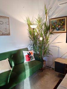 a green couch in a living room with plants at Villa Penelia next to golf courses in Romanu