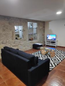 a living room with a couch and a flat screen tv at Casa do Pomarelho in Póvoa de Lanhoso
