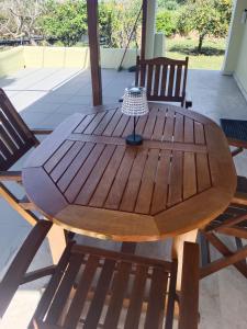 a wooden table with two chairs and a lamp on it at Villa Penelia next to golf courses in Romanu
