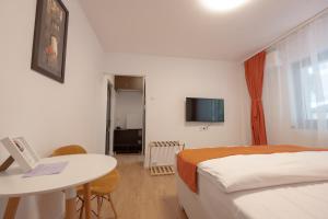 a hotel room with a bed and a table with a laptop at 3 Baneasa Airport in Bucharest