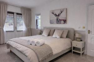 a bedroom with a bed with two towels on it at Daviot Lodge in Inverness