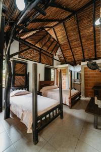 two beds in a room with wooden ceilings at Hostal La Media Luna Palomino in Palomino
