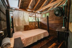 a small room with a bed in a wooden cabin at Hostal La Media Luna Palomino in Palomino