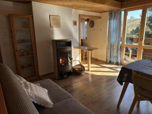 a living room with a fireplace and a table at Chata Dolce in Trutnov
