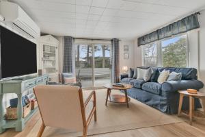 a living room with a blue couch and a tv at Cornish Cottage Walk to Long Sands Beach in York