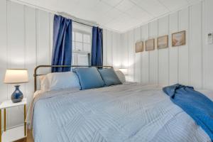 a bedroom with a blue bed and blue curtains at Cornish Cottage Walk to Long Sands Beach in York