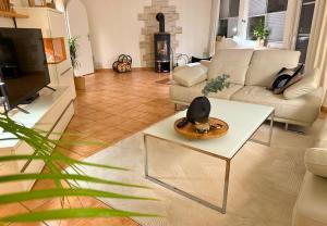 a living room with a couch and a table at Harz-Fewo Weitsicht, modern & ruhig mit 2 Balkonen, Jura Kaffeevollautomat, Kaminofen, Gäste mit Hund willkommen in Bad Harzburg