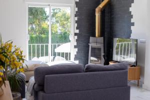 a living room with a couch and a tv at Jacarandas Islantilla in Islantilla