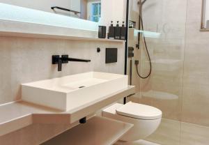 a bathroom with a sink and a toilet and a shower at Harz-Fewo Weitsicht, modern & ruhig mit 2 Balkonen, Jura Kaffeevollautomat, Kaminofen, Gäste mit Hund willkommen in Bad Harzburg +19 photos