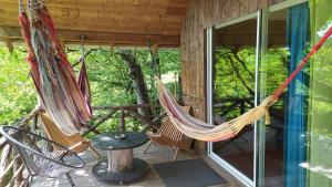a porch with two hammocks and a table at Cabane perchée in Mongauzy
