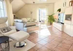 a living room with a couch and a tv at Harz-Fewo Weitsicht, modern & ruhig mit 2 Balkonen, Jura Kaffeevollautomat, Kaminofen, Gäste mit Hund willkommen in Bad Harzburg