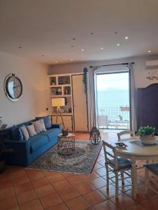 a living room with a blue couch and a table at Terrazza Miracapri in Pozzuoli