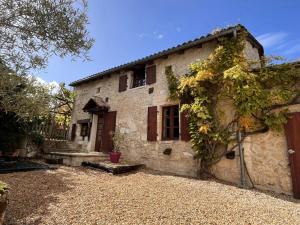 an old stone house with a yard at Fontaine de Champagne in Champagne-et-Fontaine