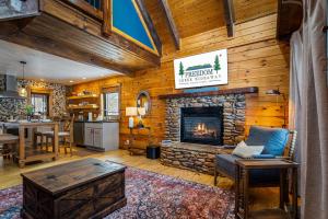 a living room with a fireplace in a log cabin at Freedom Creek Hideaway-Veteran Host-Pet Friendly-Single nights-Newly Renovated!! in Pigeon Forge