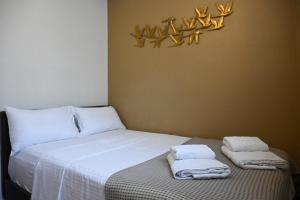 a bedroom with a bed with towels on it at Calm Breeze House in Nea Peramos