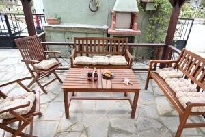 a wooden table and chairs on a patio at Calm Breeze House in Nea Peramos