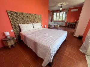 a bedroom with a large bed with orange walls at Alla Fortezza in Sarzana +28 photos