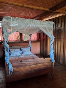 a bedroom with a canopy bed in a cabin at Hotel Anjara in Ambositra