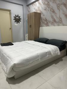 a bedroom with a large white bed with black pillows at The friendly stay in Male City +12 photos