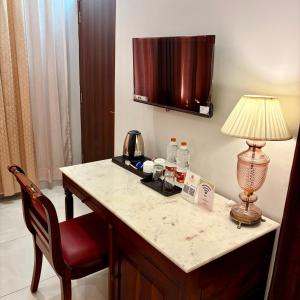 a hotel room with a desk with a lamp and a chair at Chitawa Haveli A Luxury Heritage Hotel in Jaipur