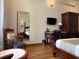 a hotel room with a bedroom with a bed and a desk at Chitawa Haveli A Luxury Heritage Hotel in Jaipur
