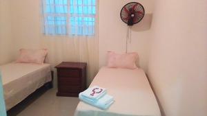 a room with two beds and a clock on the wall at Casa vacanza, Mendosa in Bayaguana
