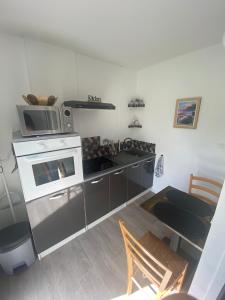 a kitchen with a stove and a microwave at Escale sous le hêtre in Ploumilliau