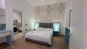 a bedroom with a bed and two tables with lamps at Sublime Bnb in Shkodër