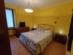 a bedroom with a bed with two towels on it at Casa Del Cuore in Torre Pellice +3 photos