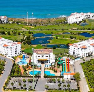 an aerial view of a resort with a pool and the ocean at Chez Charifa in Asilah +40 photos