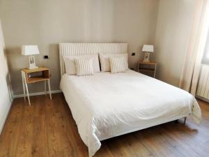 ein Schlafzimmer mit einem großen weißen Bett und zwei Lampen in der Unterkunft Da Magy in Arborea 
