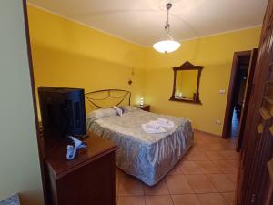 a bedroom with a bed and a tv and a mirror at Casa Del Cuore in Torre Pellice