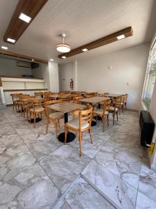 a dining room with wooden tables and chairs at Continente Park in San Clemente del Tuyú
