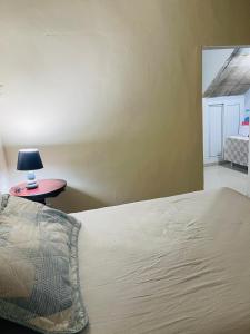 a bedroom with a bed and a table with a lamp at Vista colonial suite in Comayagua