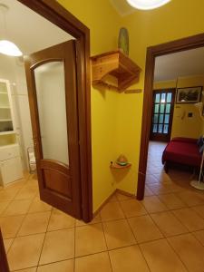 a room with a door and a yellow wall at Casa Del Cuore in Torre Pellice