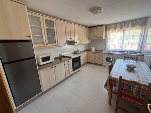 a kitchen with a table and a refrigerator at Casa cerca de Las Medulas in Puente de Domingo Flórez +20 photos